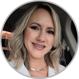 Foto Angélica sorrindo com cabelo loiro e uma blusa banca.